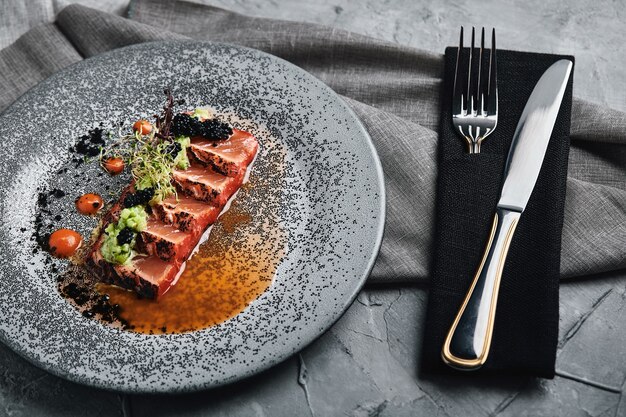 Vista superior de tagliata de salmón a la parrilla, hermosa mesa, hermosa porción, comida tradicional italiana, fondo gris, espacio de copia. concepto de comida.