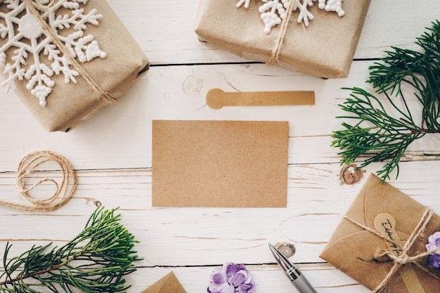 Vista superior de la tarjeta de Navidad vacía en la mesa de madera con decoración de Navidad.