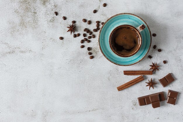 Vista superior de una taza de café con especias de anís canela y trozos de chocolate