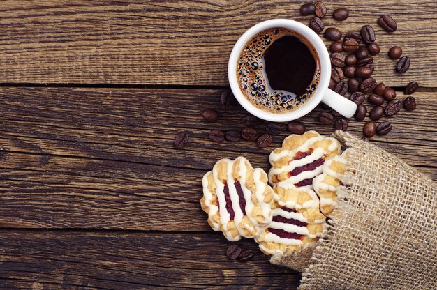 Vista superior de la taza de café y galletas en la mesa de madera