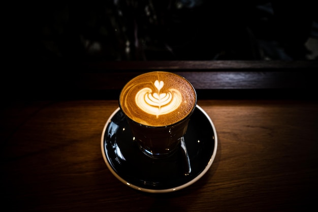 Vista superior de una taza de café con leche con espuma en forma de hoja