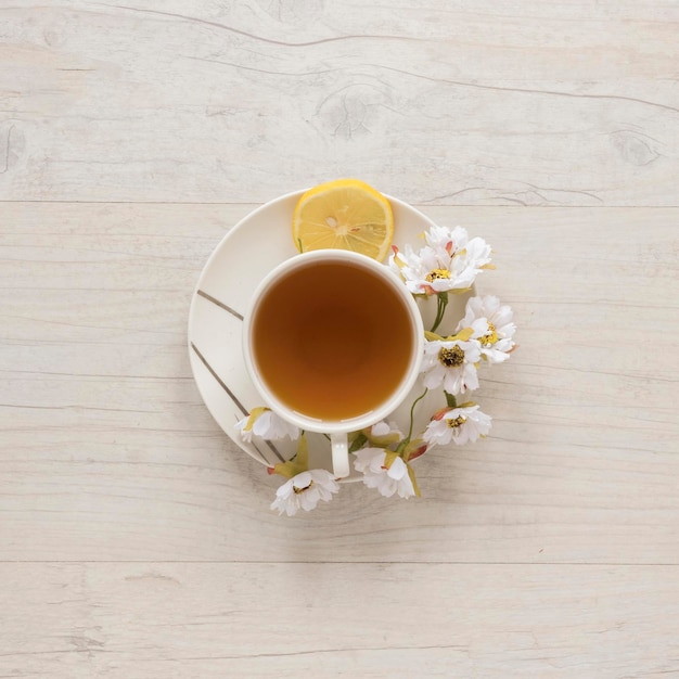 vista superior taza de té de limón con flores platillo de limón