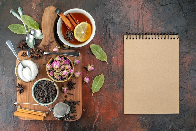 Vista superior taza de té con té negro y flores secas en el fondo marrón oscuro té agua color desayuno foto bebida ceremonia galleta