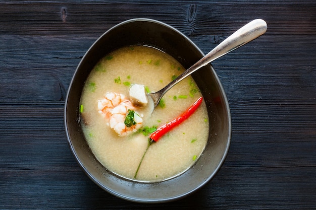 Vista superior del tazón con sopa Tom Kha Thale en la oscuridad