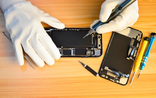 Foto vista superior de un técnico reparando un teléfono inteligente