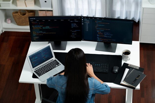 Vista superior de TI asiática creando con la escritura de información en línea en el ordenador Stratagem