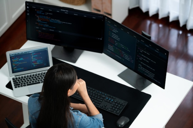 Vista superior de TI asiática creando con la escritura de información en línea en el ordenador Stratagem