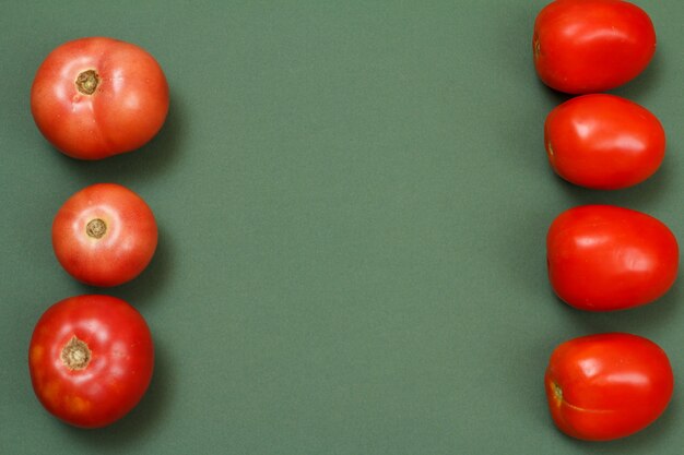 Foto vista superior de tomates frescos sobre fondo verde. verduras en la mesa de la cocina. vista superior.