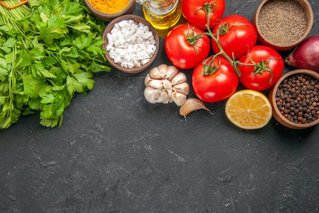 Vista superior de tomates rojos frescos con verduras y condimentos