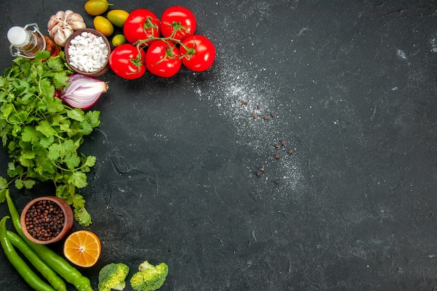 Vista superior de tomates rojos frescos con verduras y condimentos