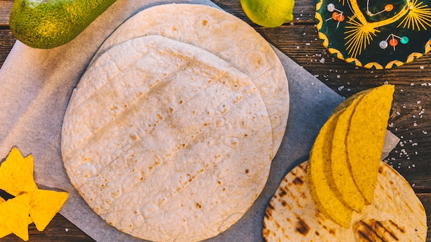 Foto vista superior de la tortilla mexicana y sabrosos nachos en mesa de madera