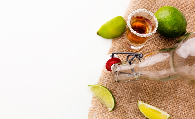 Foto vista superior de trago de tequila y rodajas de limón con espacio de copia