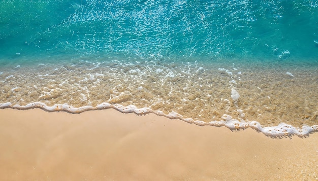 Vista superior de una tranquila escena de playa que presenta el movimiento del mar azul y las olas en la costa del océano.