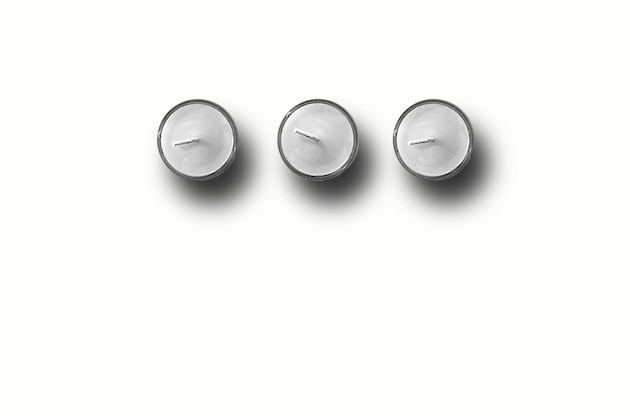 Vista superior de tres velas blancas en fondo blanco adecuado para su elemento de diseño