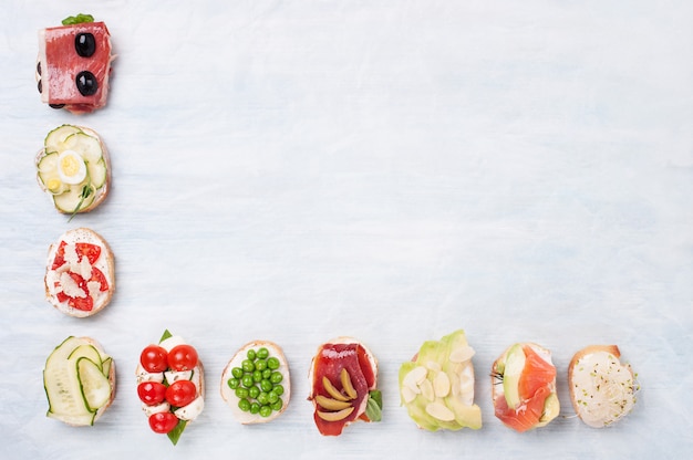 Vista superior de la variedad de sándwiches saludables en papel pergamino con espacio para texto.