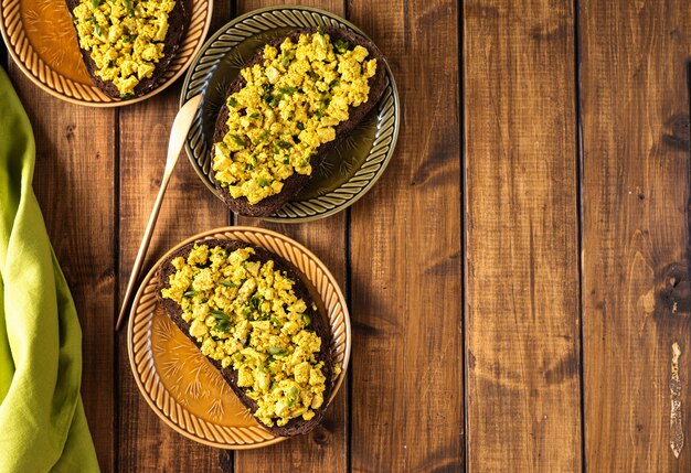 Vista superior de varios platos con coloridos sándwiches veganos de ensalada de huevo