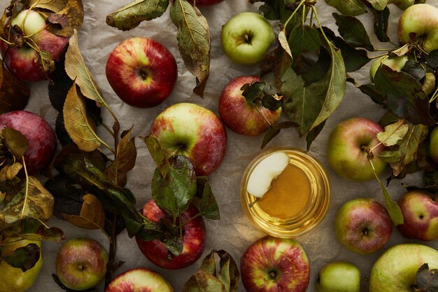 vista superior del vidrio con sidra cerca de las manzanas esparcidas