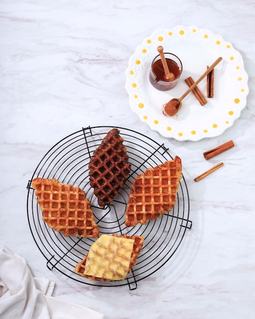 Vista superior Waffle Croffle Croisant con varios aderezos, queso, chocolate, azúcar y canela. Croffle es comida callejera viral de Corea.