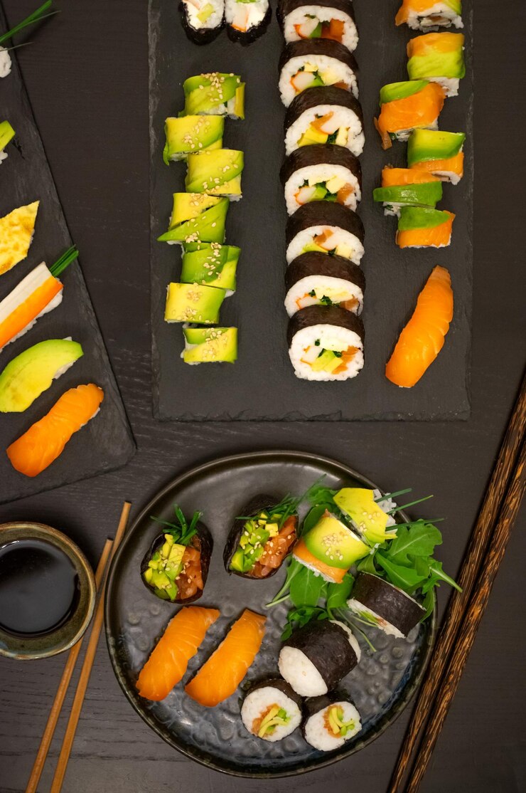 Vista superior zenital del lujoso y creativo sushi como Nigiri Futomaki Uramaki con palillos y soja