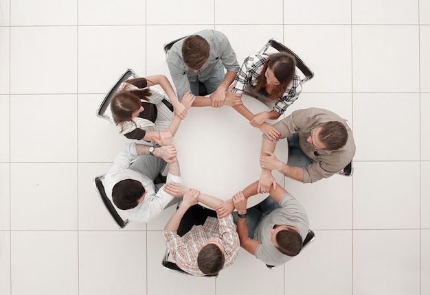 Vista superiorEl equipo de negocios se toma de la mano formando un círculoel concepto de unidad