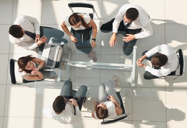 Vista superiorequipe de negócios sentada à mesa do escritório o conceito de trabalho em equipe