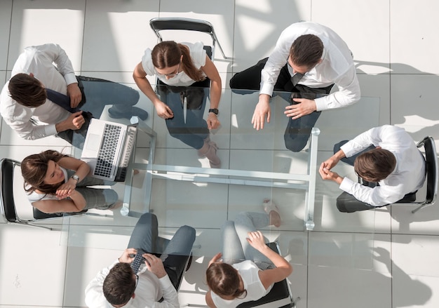 Vista superiorequipe de negócios sentada à mesa do escritório o conceito de trabalho em equipe