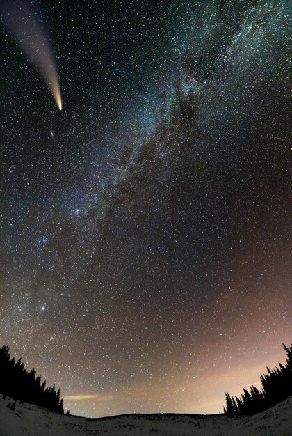 Vista surrealista de la noche en las montañas con cielo nublado azul oscuro estrellado