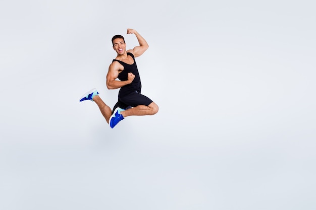 Foto vista del tamaño del cuerpo de longitud completa de atractivo chico deportivo musculoso saltando celebrando regocijo