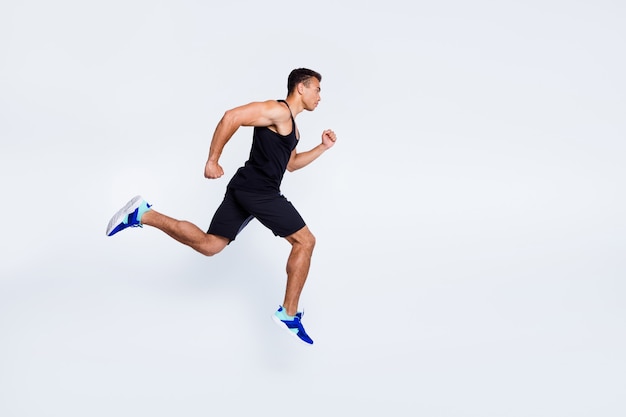 Foto vista del tamaño del cuerpo de longitud completa de chico musculoso resuelto saltando corriendo trotar distancia de sprint