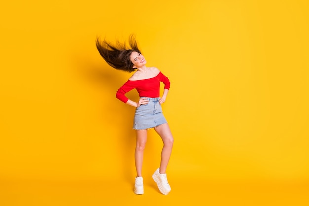 Vista del tamaño del cuerpo de longitud completa de ella ella agradable atractiva adorable esbelta alegre alegre chica posando tirando cabello sano aislado sobre fondo de color amarillo vibrante brillante brillo vivo