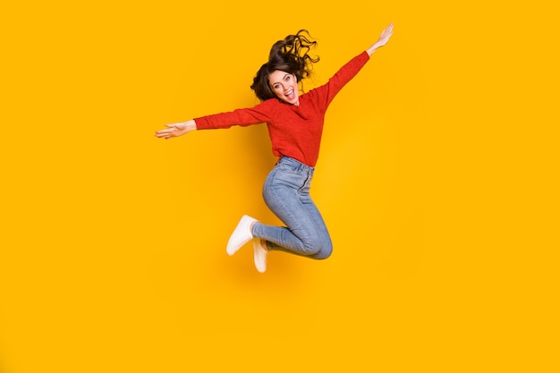 Vista del tamaño del cuerpo de longitud completa de ella ella agradable atractivo bastante alegre alegre delgado ajuste chica de cabello ondulado saltando divirtiéndose en el tiempo libre vacaciones aislado brillante vivo brillo vibrante fondo de color amarillo