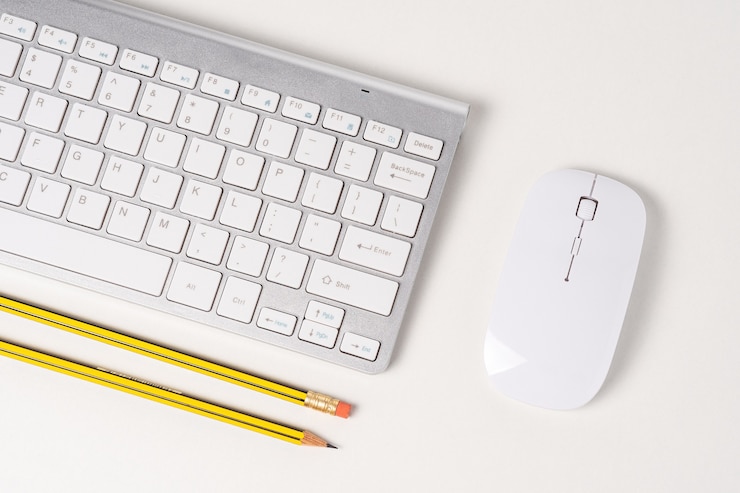 Foto vista del teclado y el mouse de una computadora moderna con lápices