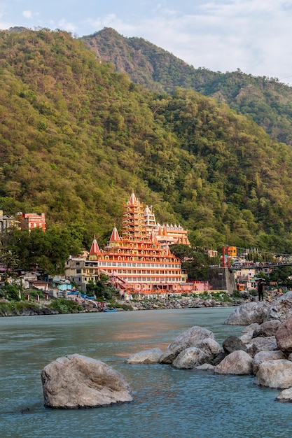 Vista del terraplén del río Ganges, el puente Lakshman Jhula y el templo Tera Manzil, Rishikesh, India