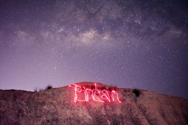 Foto vista de texto escrito en el desierto contra el cielo nocturno