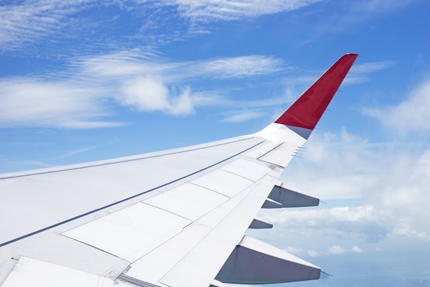 Vista de la tierra, la nube y el ala del avión desde la ventana