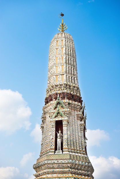 Vista de la torre lateral de Wat Arun sobre fondo de cielo azul