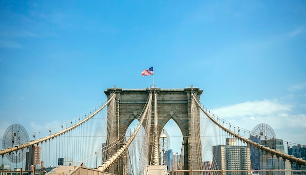 Vista de las torres del Puente de Brooklyn sobre un cielo azul con el horizonte de Manhattan en el fondo, en la Ciudad de Nueva York