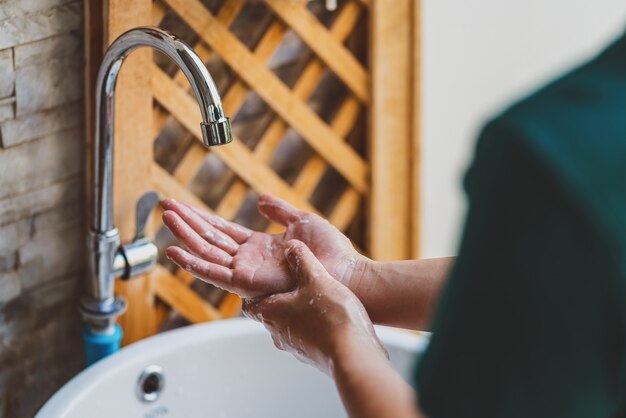 Vista traseira da lavagem das mãos com torneira e sabonete chrome para prevenção da pandemia de coronavirus