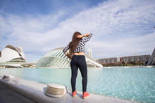 Vista traseira da mulher em pé no fundo do edifício Hemisferic. Cidade das Artes e Ciências de Valência, Espanha.