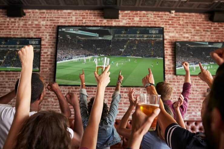 Foto vista traseira de amigos vendo jogo em bar de esportes em telas