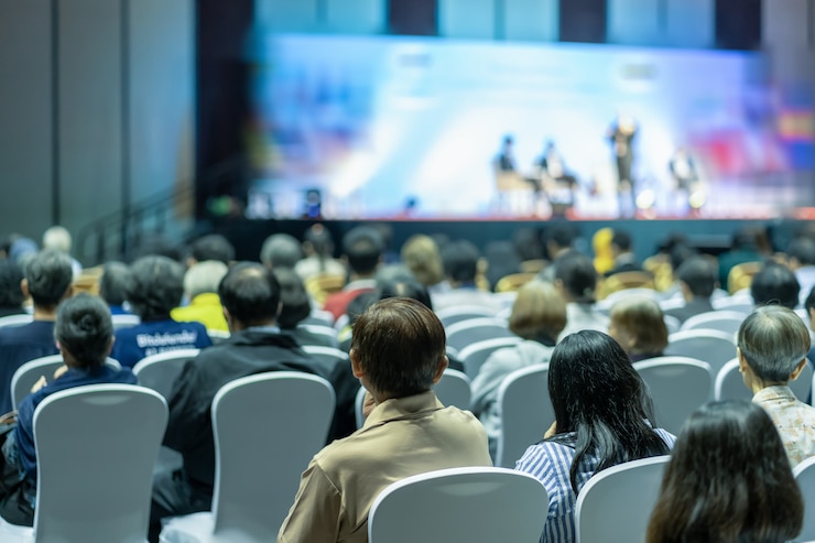 Foto vista traseira, de, audiência, escutar, alto-falantes, ligado, a, fase, em, a, corredor conferência, ou, seminário, reunião