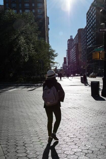 Foto vista traseira de comprimento completo de mulher caminhando na rua da cidade contra o céu durante o dia ensolarado