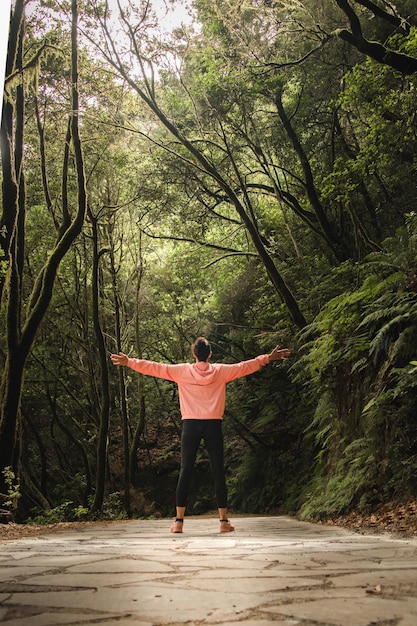 Foto vista traseira de comprimento completo de um homem de pé junto a uma árvore na floresta