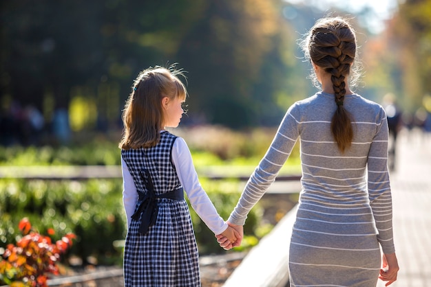 Vista traseira, de, criança menina, e, mãe, junto, segurar passa