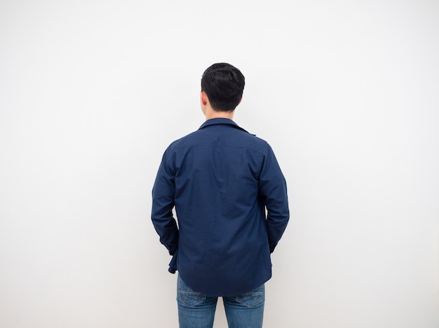 Vista traseira de homem bonito em terno jeans em pé no fundo branco do estúdio