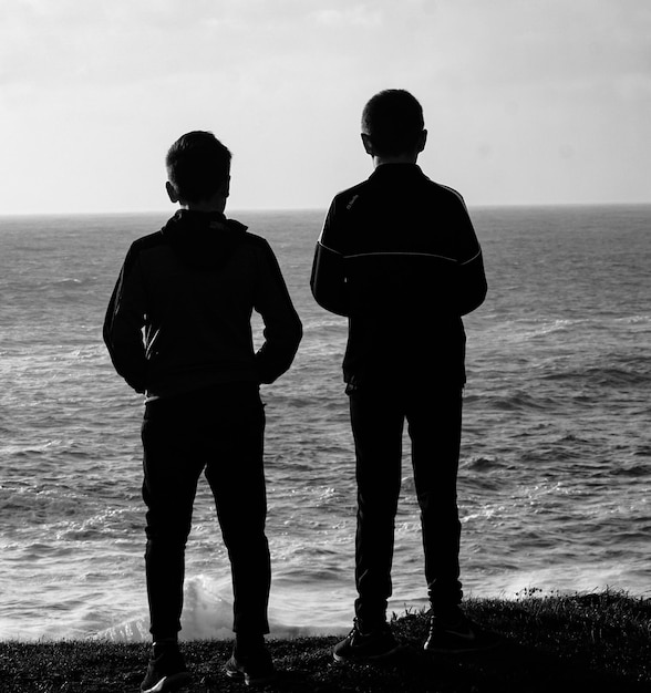 Foto vista traseira de homens de pé na praia