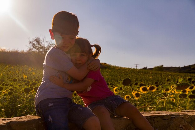 Vista traseira de mãe e filha no campo contra o céu