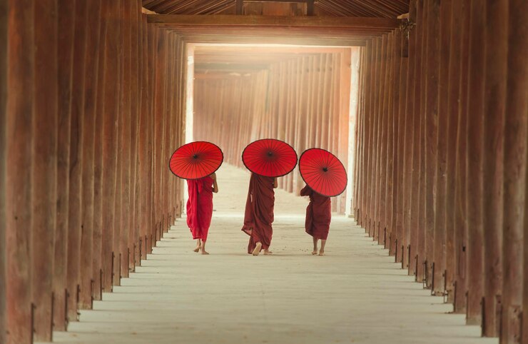 Foto vista traseira de monges com guarda-chuva de papel caminhando na passarela do pagode