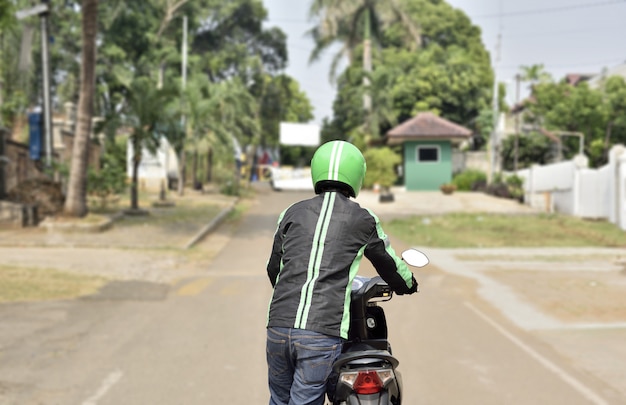 Vista traseira, de, motociclista, motorista táxi, empurrar, seu, motocicleta