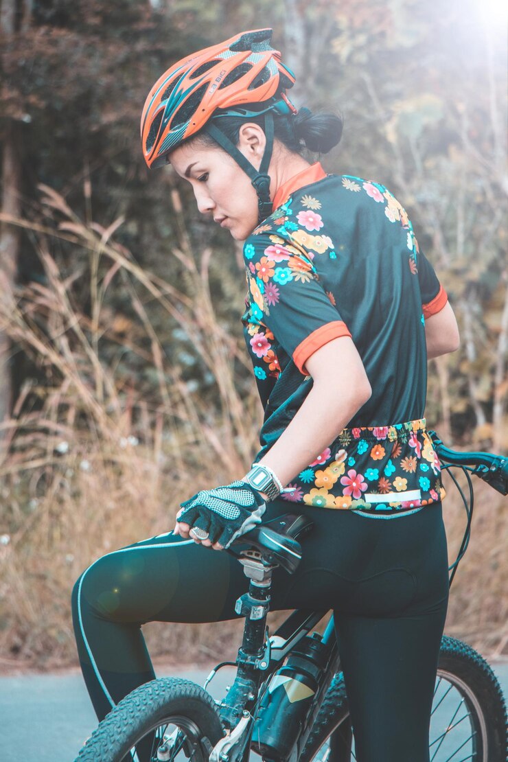 Foto vista traseira de mulher andando de bicicleta na estrada contra plantas